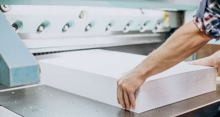 Man working in printing house with paper and paints